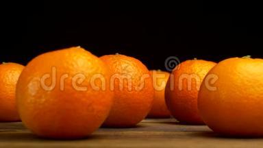 一张黑色背景的木桌上摆着一种多汁的橘子，从这张桌子上可以看到冰霜般的清新和凉爽